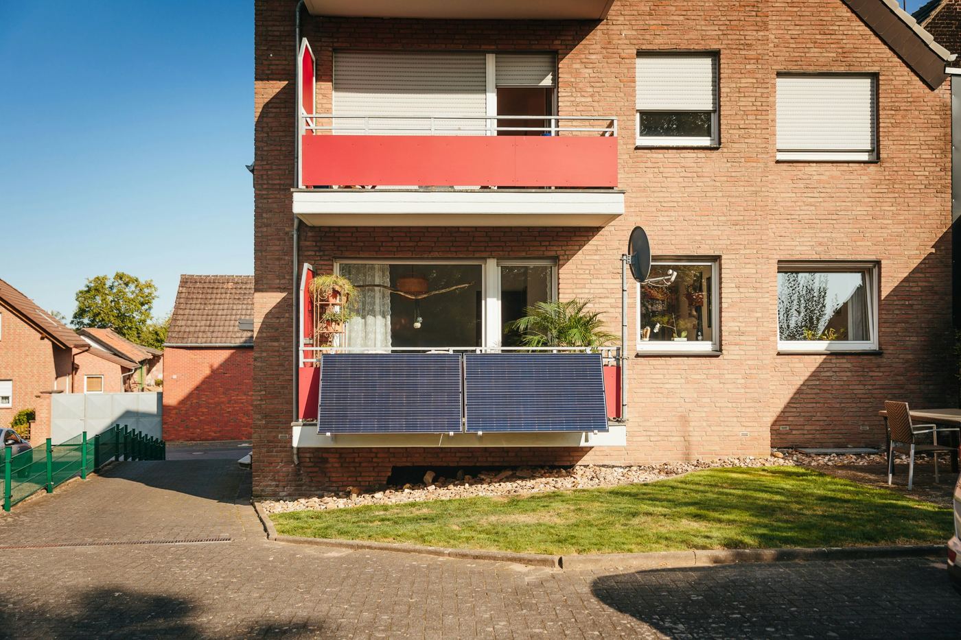 Paneles solares de balcón en la fachada de un edificio de pisos de ladrillo